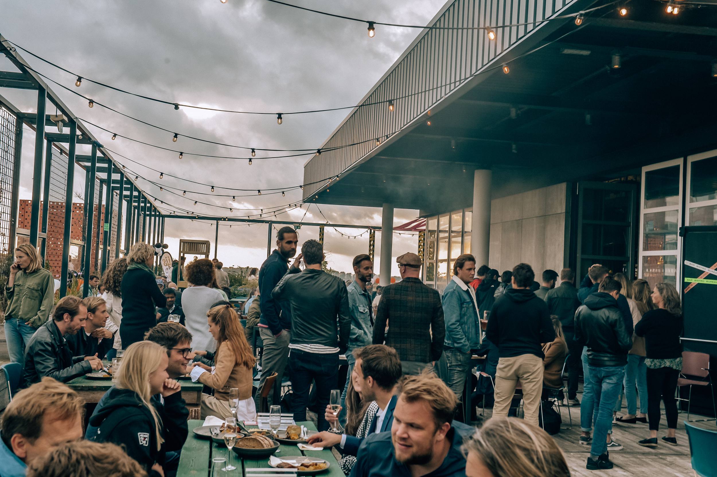 Overdekt terras vol gasten tijdens een event
