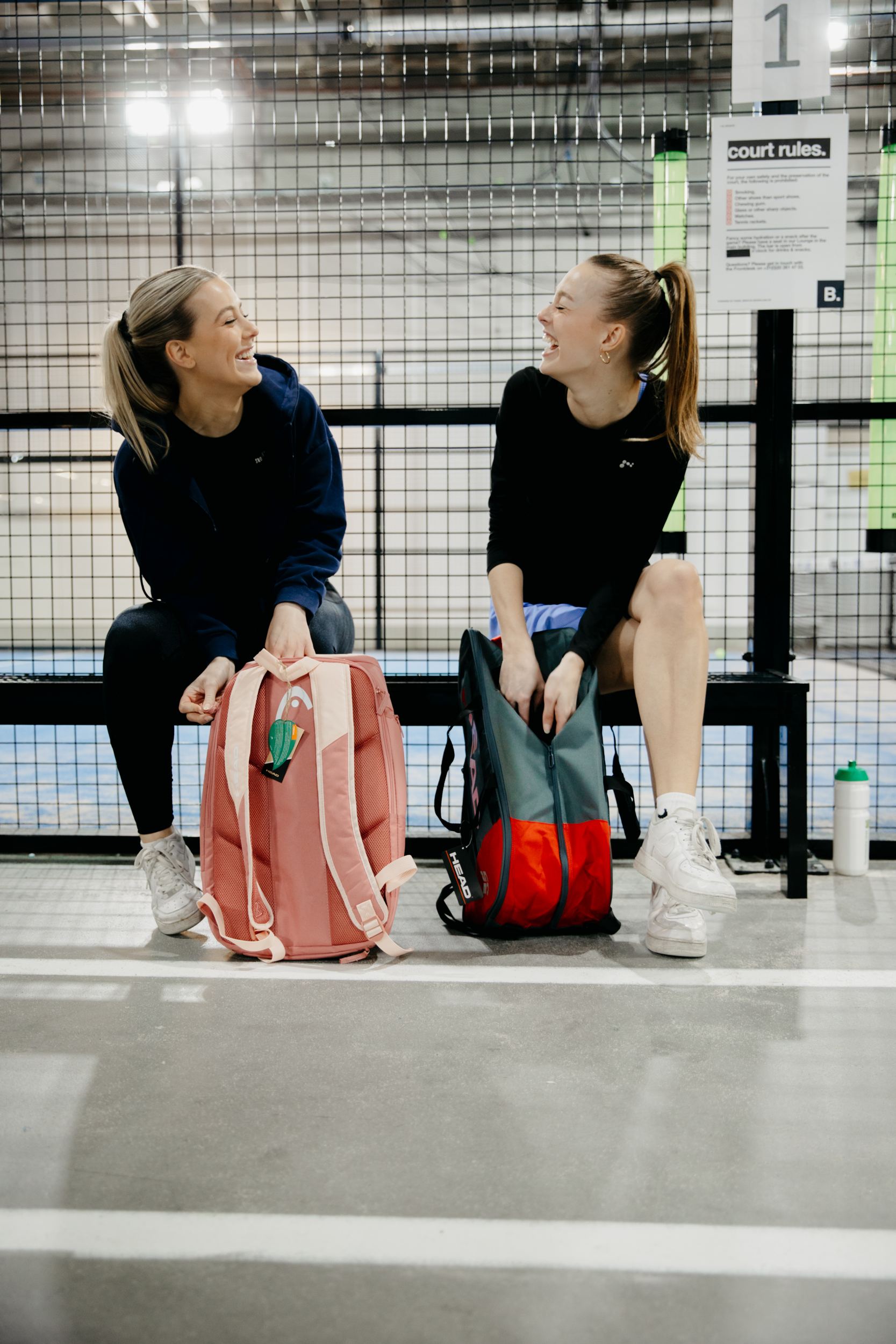Twee speelsters op een bankje langs de baan