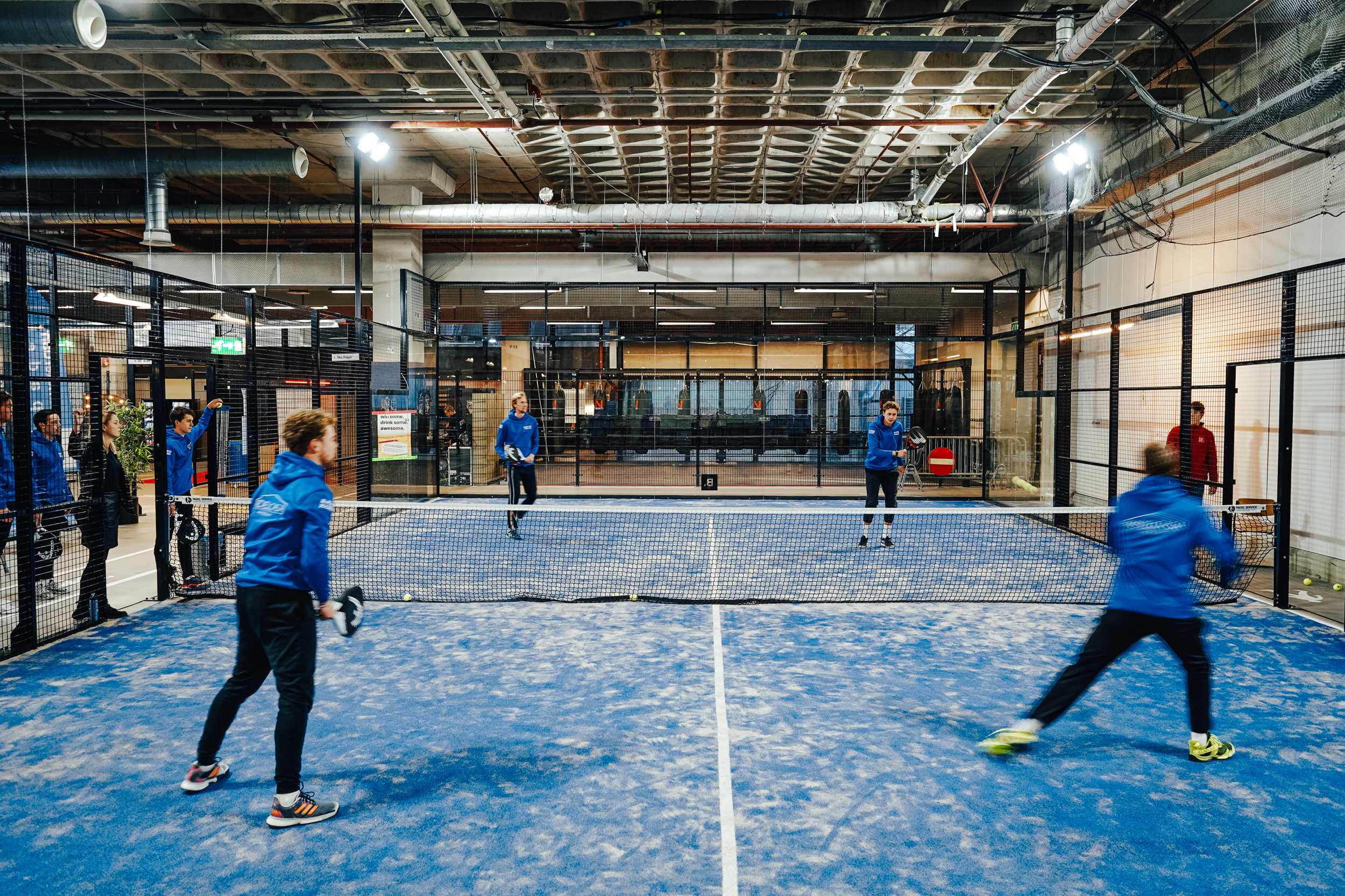 Vier spelers op een indoor padelbaan in B.1