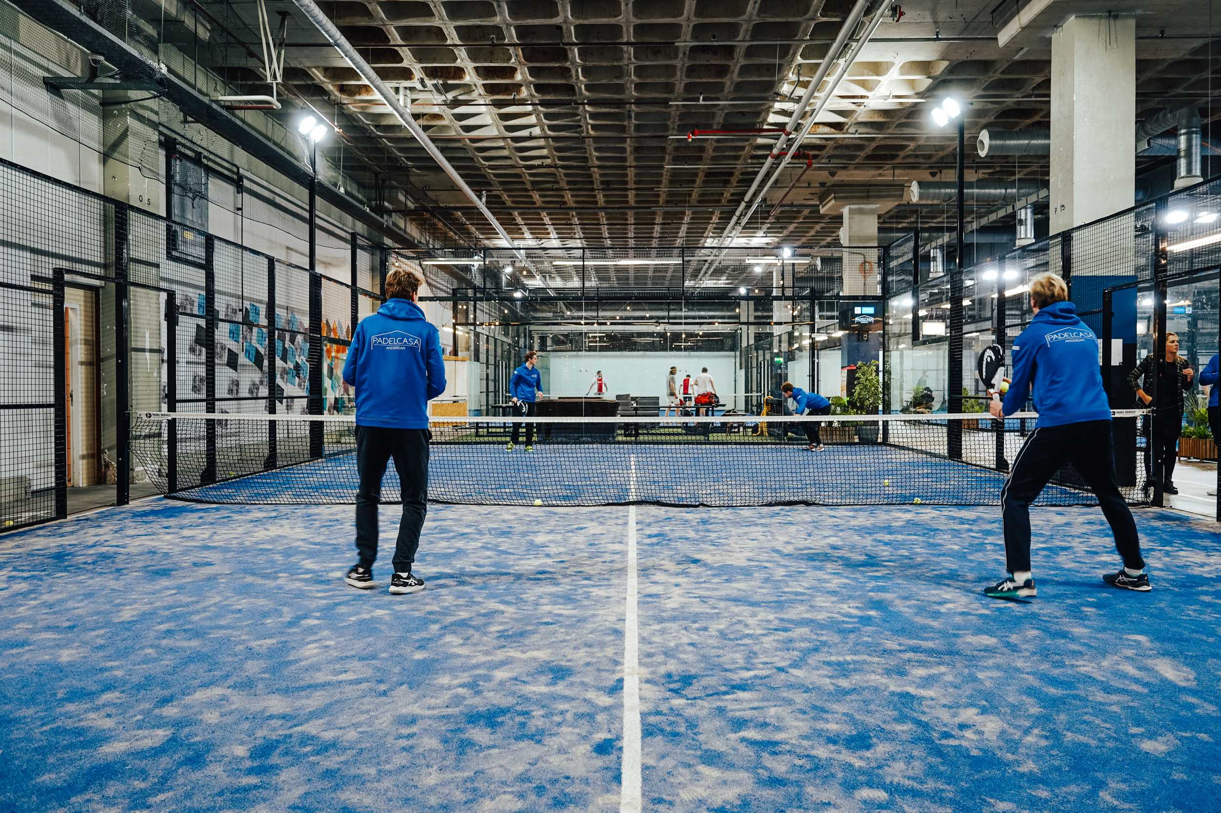 Padelwedstrijd op een blauwe indoorbaan